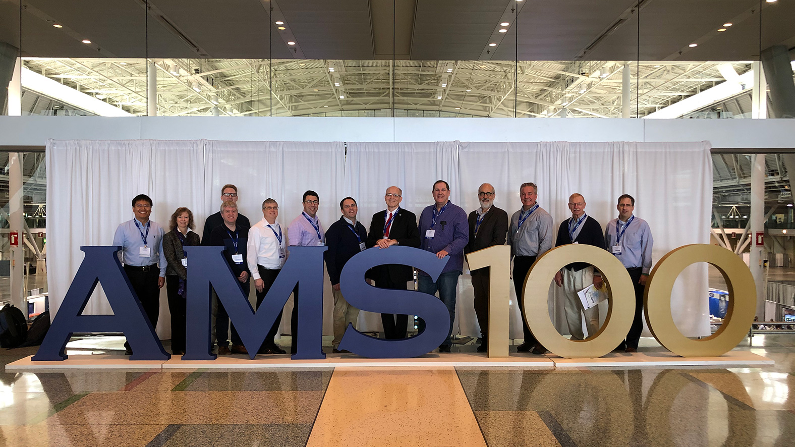 MDL staff members gather for a group photo at a popular spot in the lobby of the Convention Center:  From left, Huiqing Liu, Judy Ghirardelli, Phil Shafer, Justin Wilkerson (behind Phil), Dave Rudack, Dana Strom, Jason Burks, Steve Smith, Greg Stumpf, Dave Ruth, Ken Sperow, Jess Charba, and Andy Kochenash.